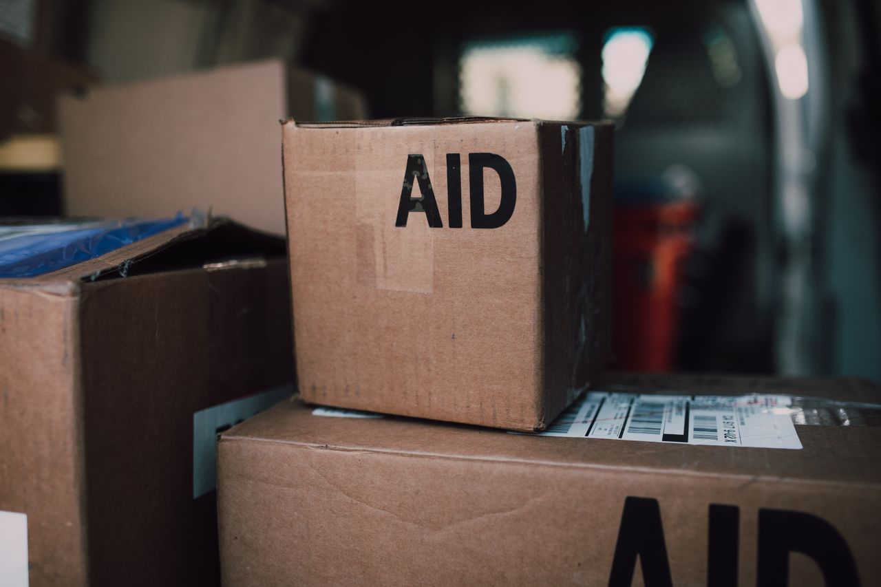 about-us Stacked aid boxes ready for distribution in a delivery vehicle.